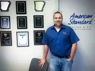 Owner Bruce Floss shows off a wall of plaques and awards for excellent customer service.